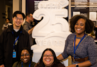 A photo shows four Audible employees standing around a white sculpture that says "Audible 25 Years".