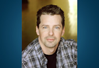 Actor Sean Hayes, seated, stares into the camera.