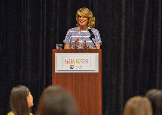 Audible's Chief People Officer, Anne Erni, stands behind a podium giving a talk.