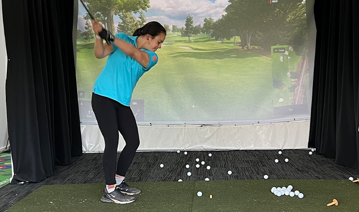 A scholarship recipient enjoys a golf simulator as part of the Central Coast District's fun night.