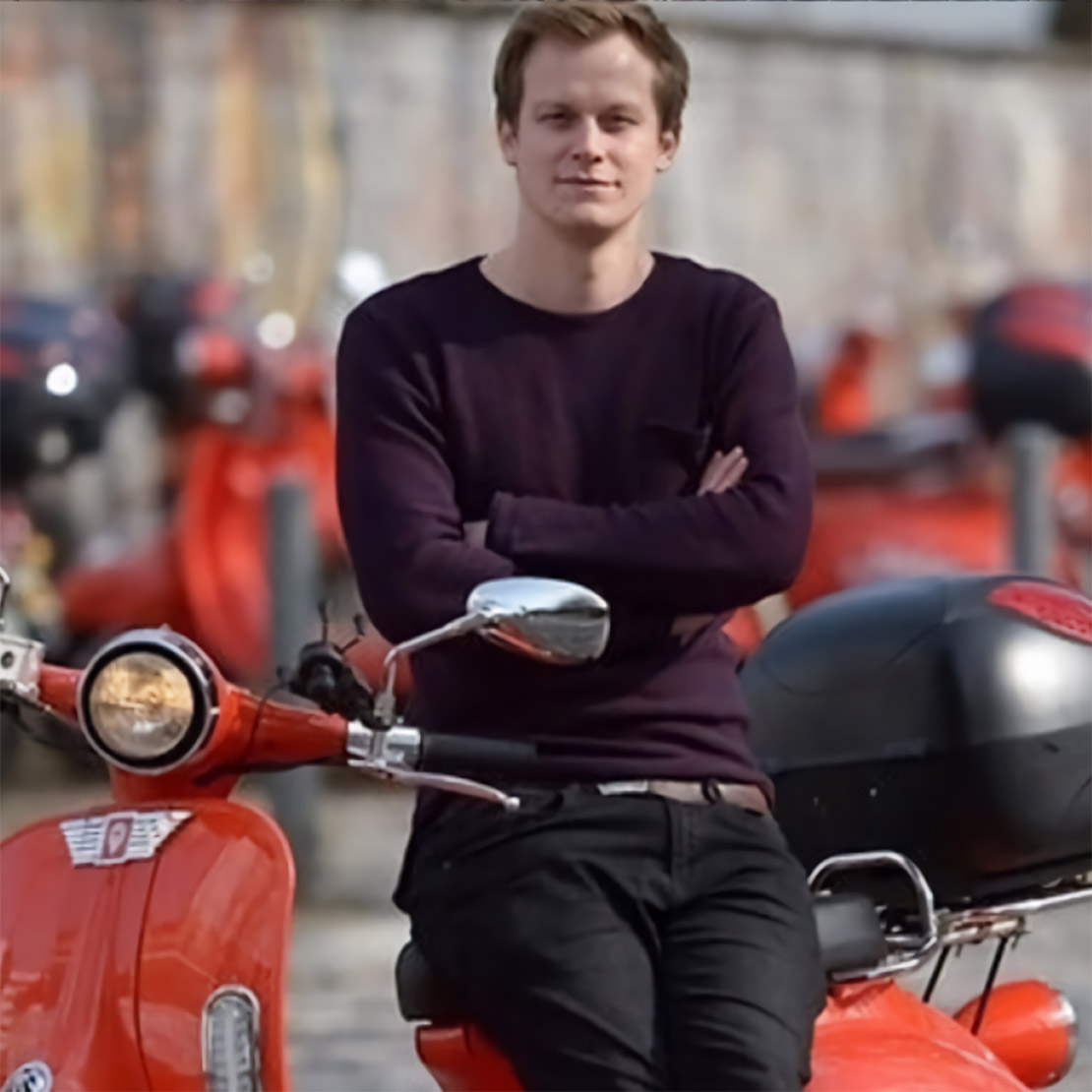 Valerian Seither sitzt mit verschränkten Armen auf einem Moped.