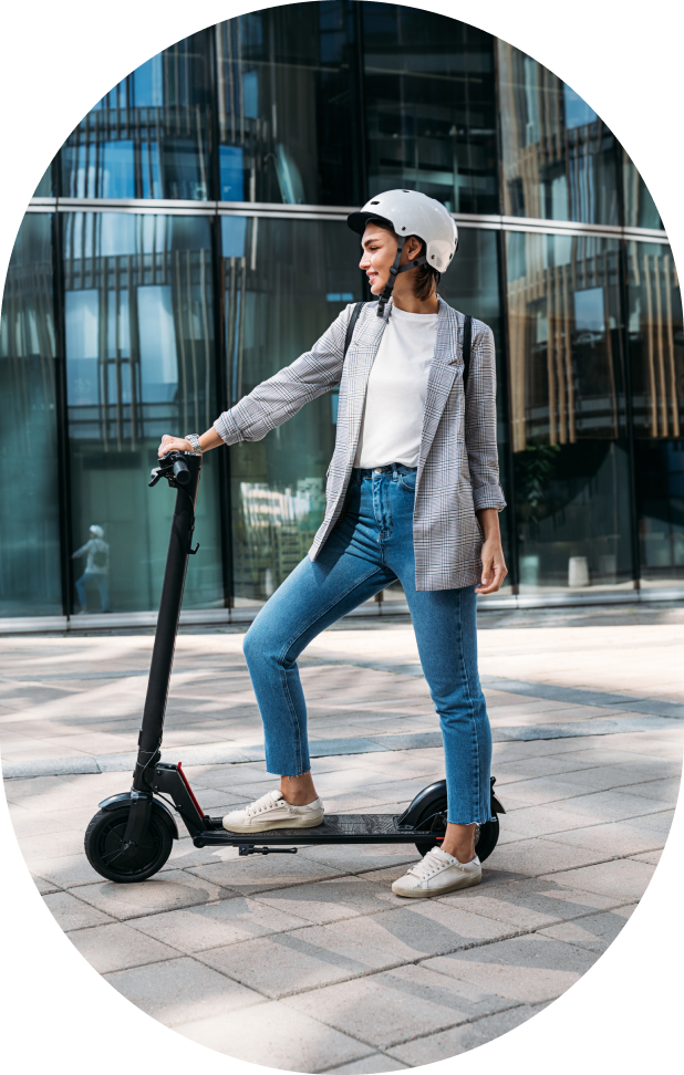 A caucasian woman with a white helmen holding a kickscooter.