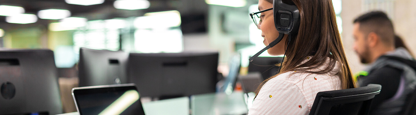 Call center employee at her desk with headset on