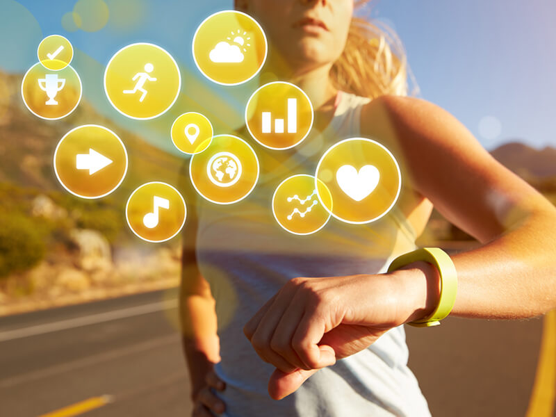 woman wearing IoT-enabled watch with multiple health icons indicated