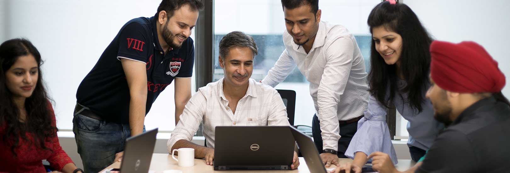 TELUS International employees looking at laptops