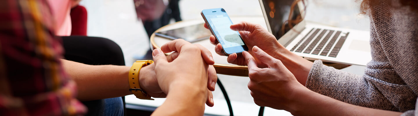 A person showing her phone to another person in a meeting