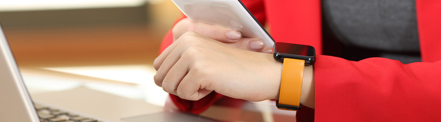 Person looking at their apple watch with mobile phone in other hand