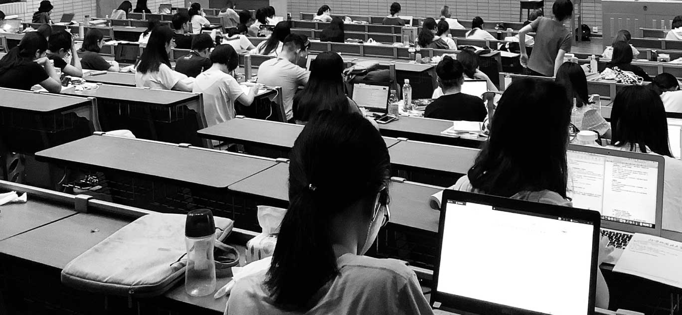 Students in a classroom using laptops during a lecture.