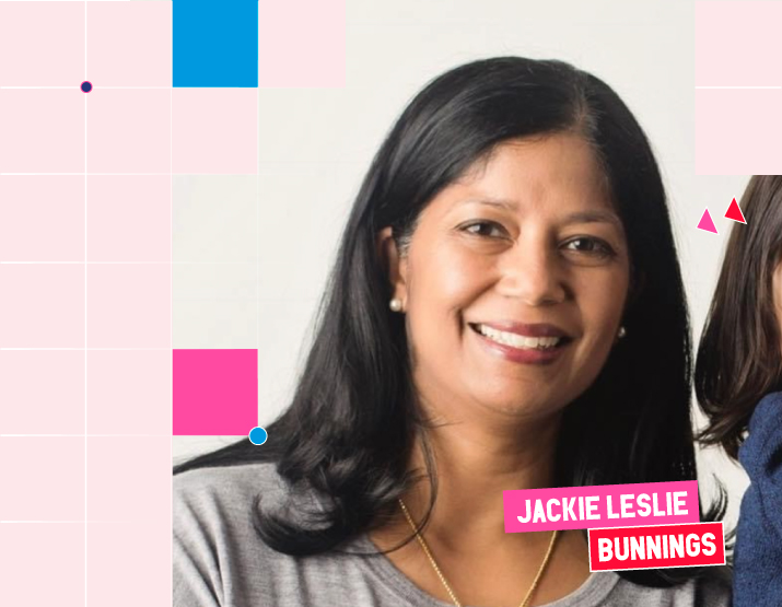 A brightly lit photograph of Jackie Leslie, a woman with dark hair wearing a grey sweater and long gold necklace. She is smiling direct to camera. Square graphic elements, which are set against a pink backdrop, border the image. Across the bottom right of the image, her name is included in block letters against a pink background. Underneath her name, BUNNINGS is written in white block letters against a red background.