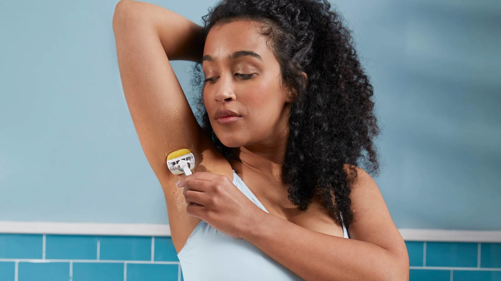 Kvinna som rakar hennes armhåla med Venus rakhyvel