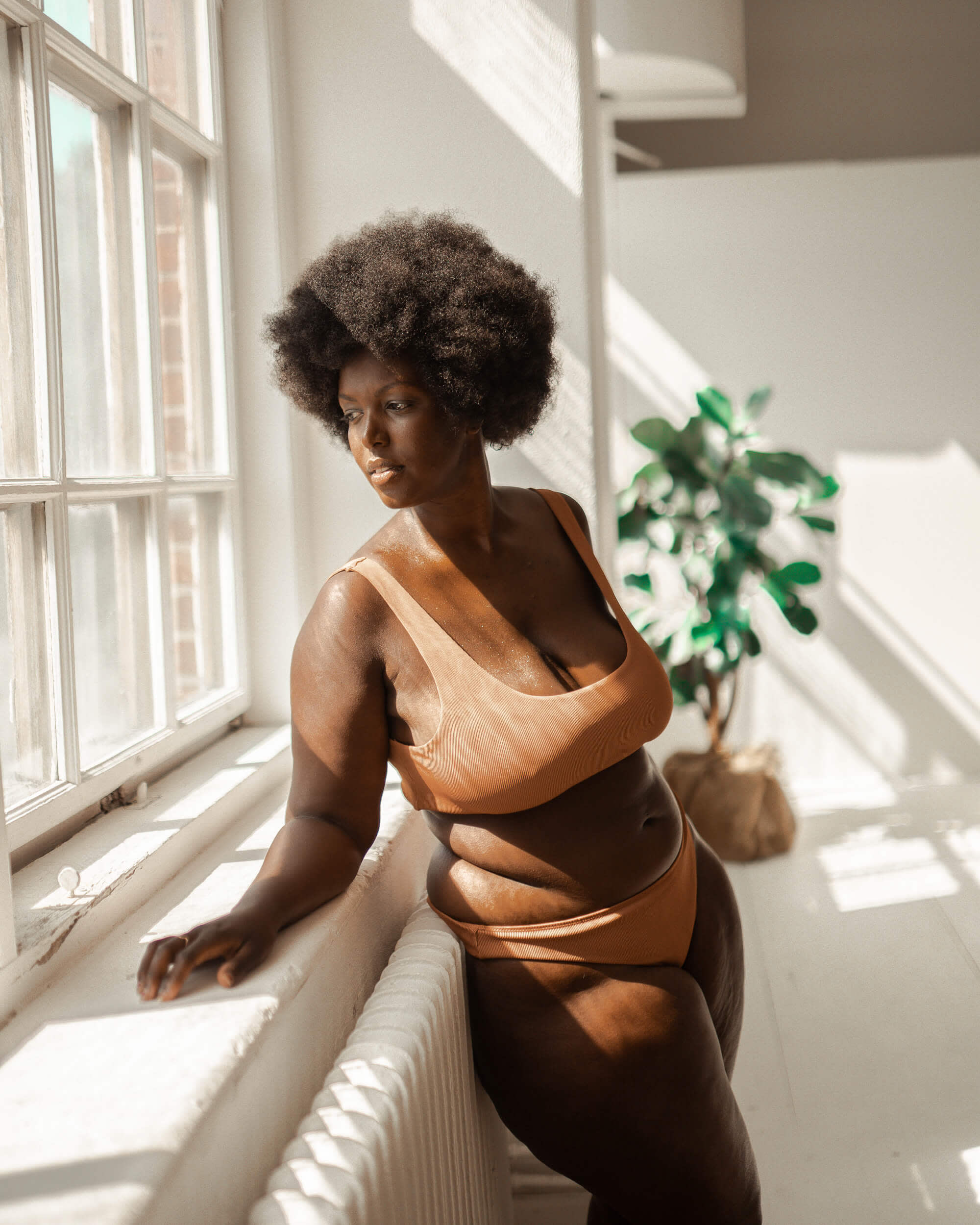 En person i en baddräkt lutad mot en fönsterkant