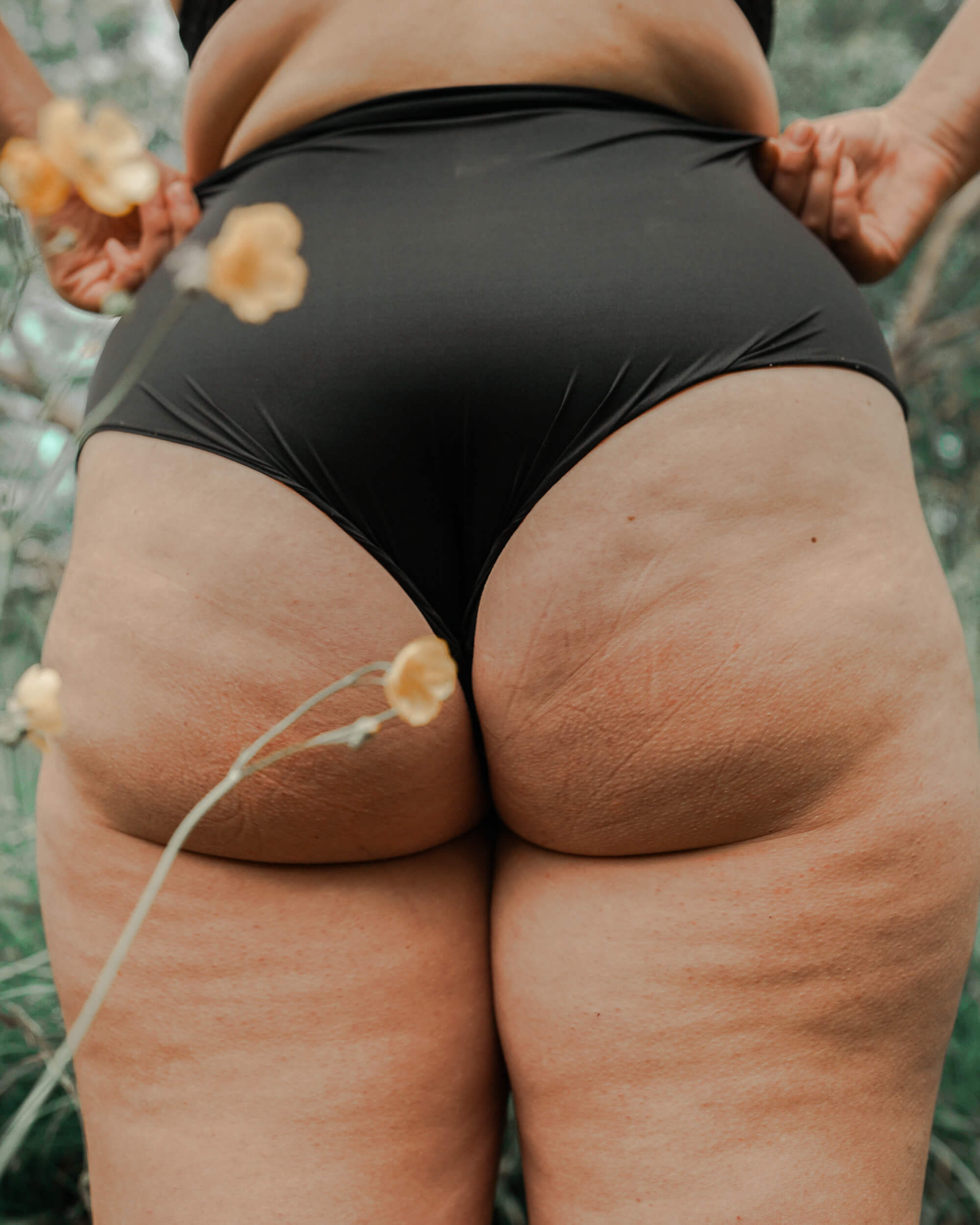 Närbild av en person bakom i svarta underkläder som visar hudstruktur