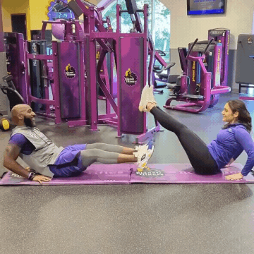 Man and woman working out in Planet Fitness gym doing leg circles