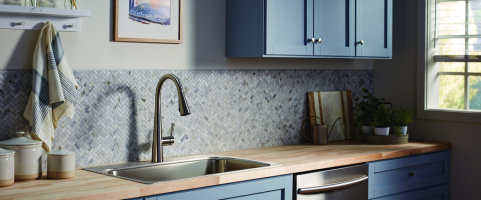 Dapur dengan kabinet biru, kitchen sink stainless steel, dan kran pull-down