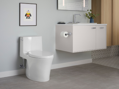 Kloset duduk putih dan wastafel gantung dalam kamar mandi modern