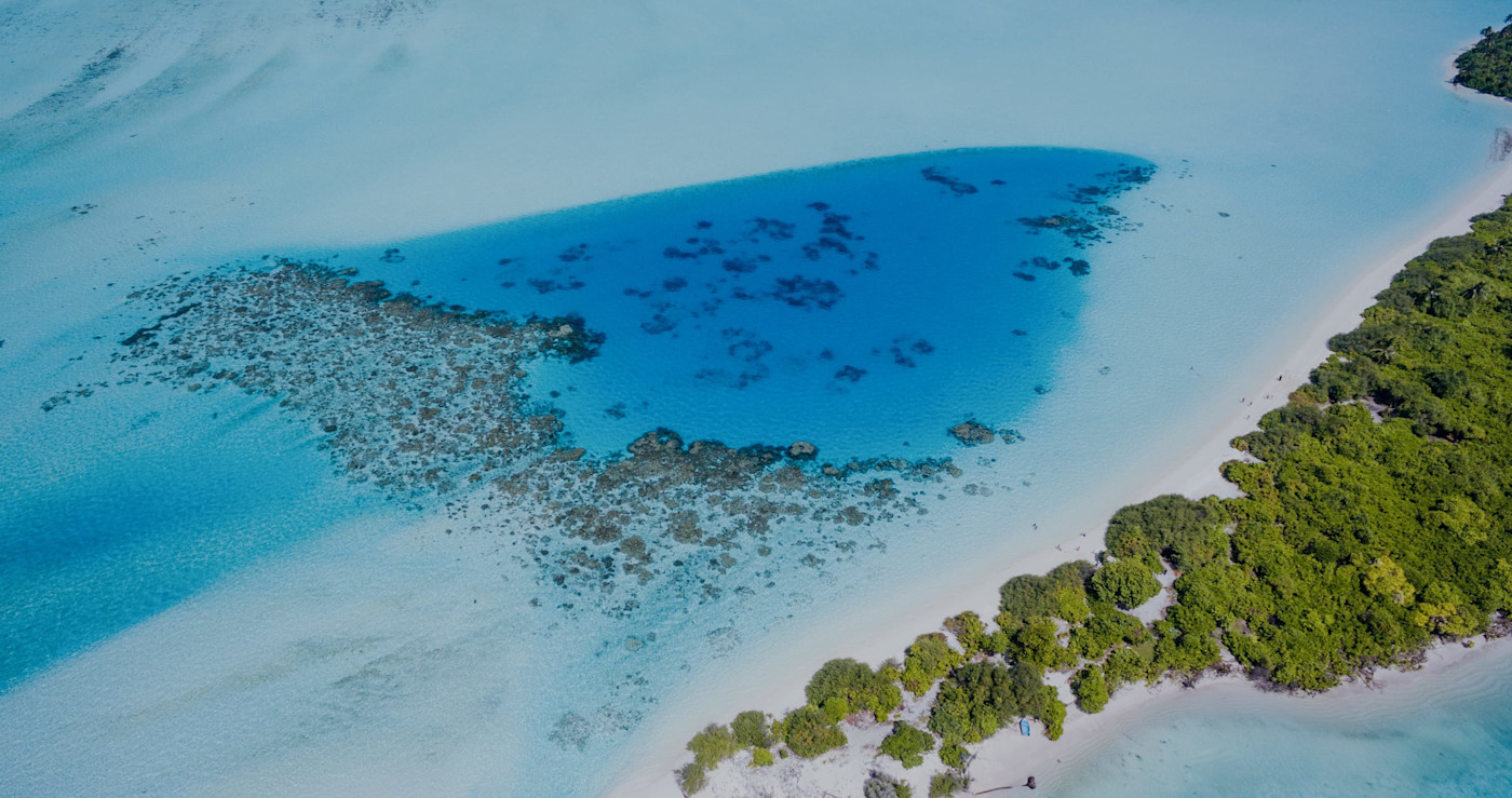 Aerial view of an island with a turquoise water sea on the background