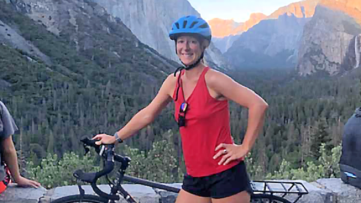 Sharon Eriksen is pictured in the mountains next to her bike.