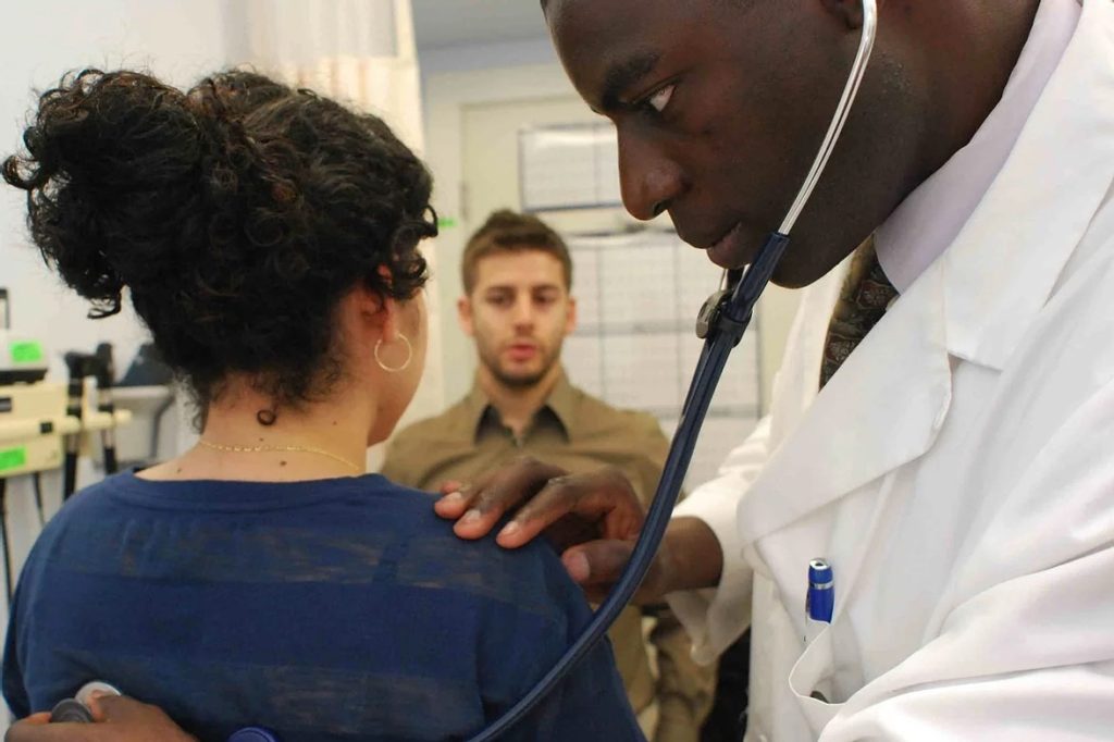 Haven free clinic using stethoscope on woman