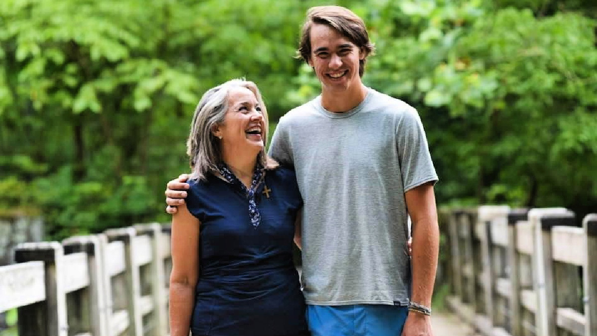 Jere Downs and her son, outdoors on a wooden bridge footpath
