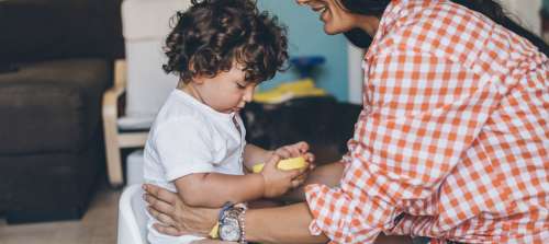A caregiver potty training a child.