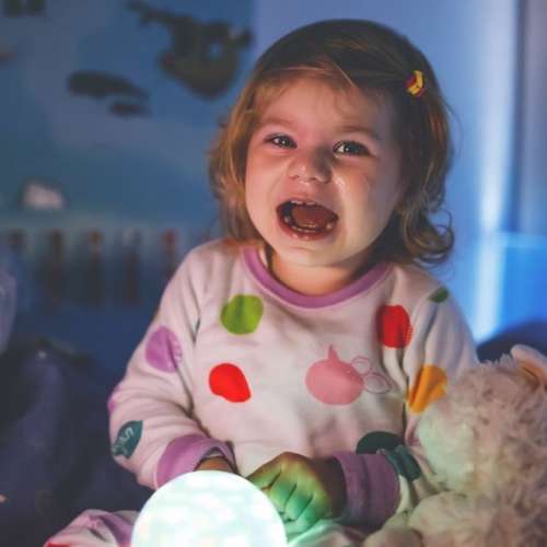 Toddler sitting up in bed after having nightmare or night terror