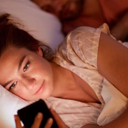 Woman laying in bed on cellphone