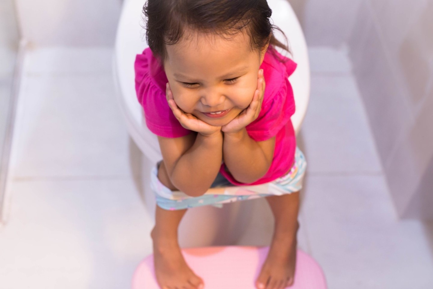 How to make toddler poop instantly: Toddler smiling while sitting on potty