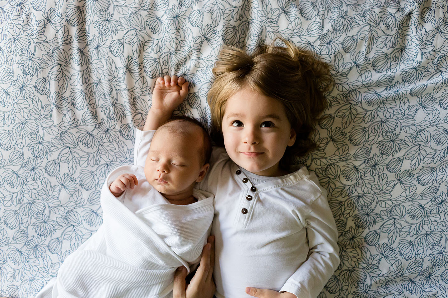 Siblings laying next to one another | Huckleberry