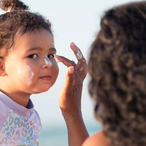Mom applies safe sunscreen for baby to protect her skin