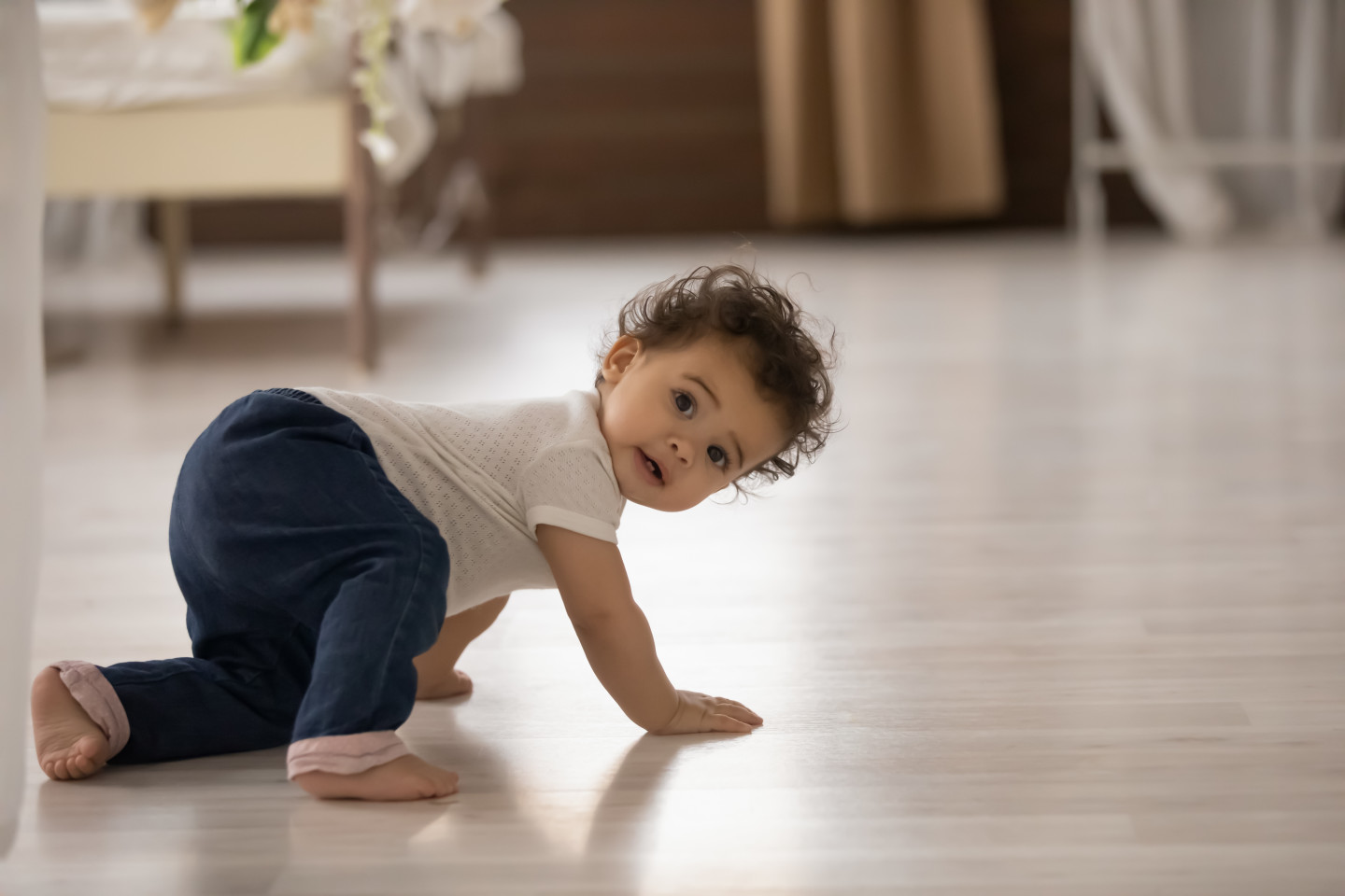 A baby doing a crab crawl on the floor.