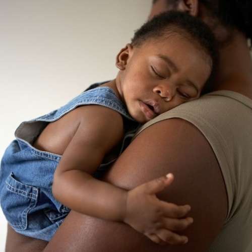 Baby sleeping in mother's arms
