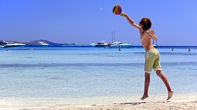 Kind spielt Beachball am Strand
