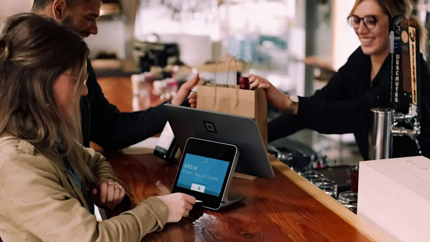 Photo of people in a bar paying with their credit card