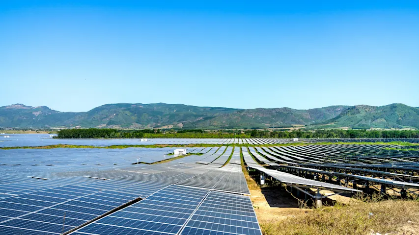Image of a fields of solar panels in a sunny landscape
