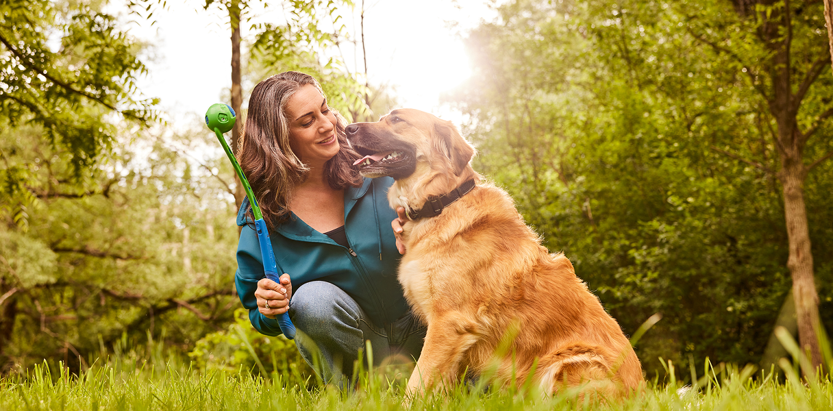 A woman playing with her pet dog in a park