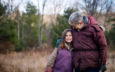 Susan Benedict stands with her granddaughter on the family's woodland in State College, PA. 