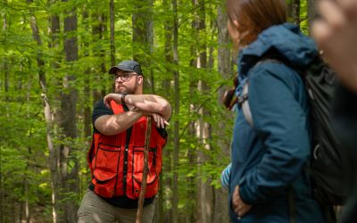 American Forest Foundation Forester, Ian Forte, standing in West Virginian woods as he tells landowners about sustainable forest management practices.