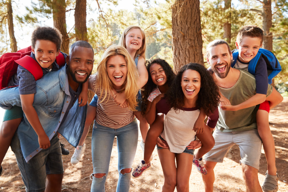 A group of people smiling in a forest.