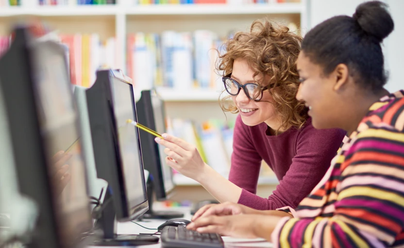 A tutor workng with someone on a computer.