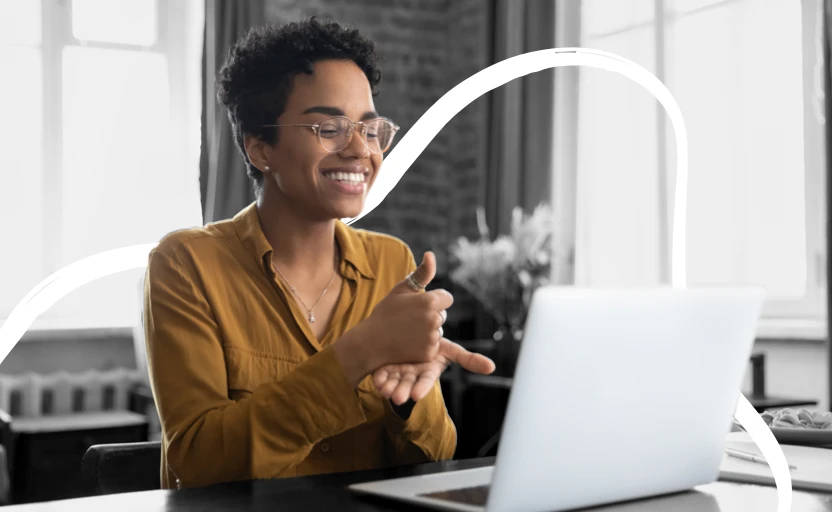 A person using sign language to communicate while on a video interview on their laptop.