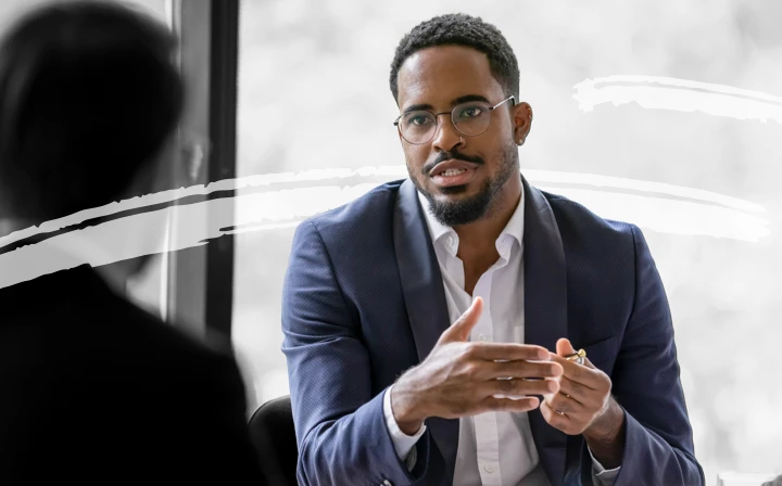 A man speaking in a work meeting or job interview.