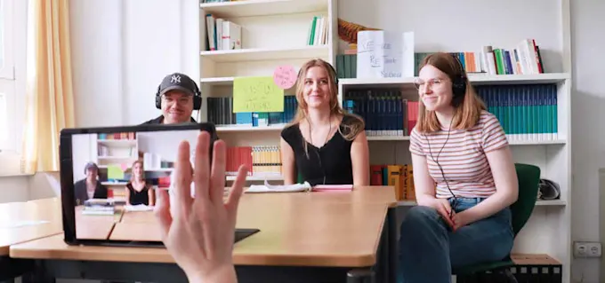Drei Personen sitzen vor einer Kamera und nehmen ein Video auf