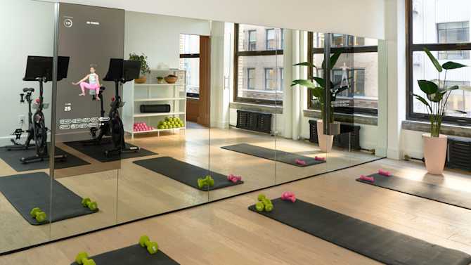 Image of fitness room with yoga mats, mirrors, and cycling bikes