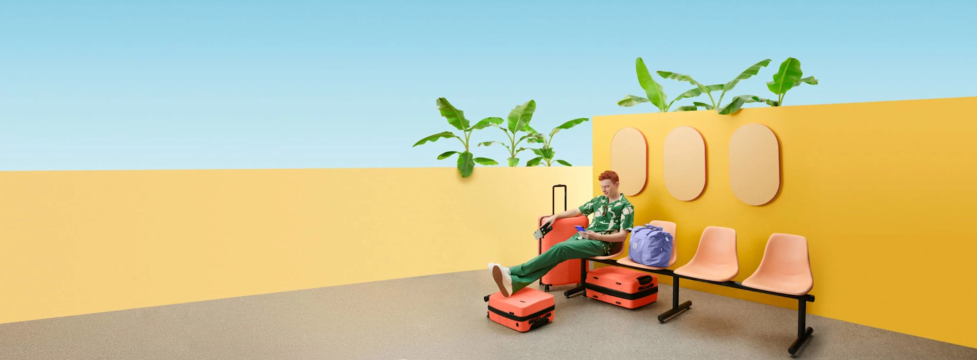 man sitting on a chair surrounded by luggage.