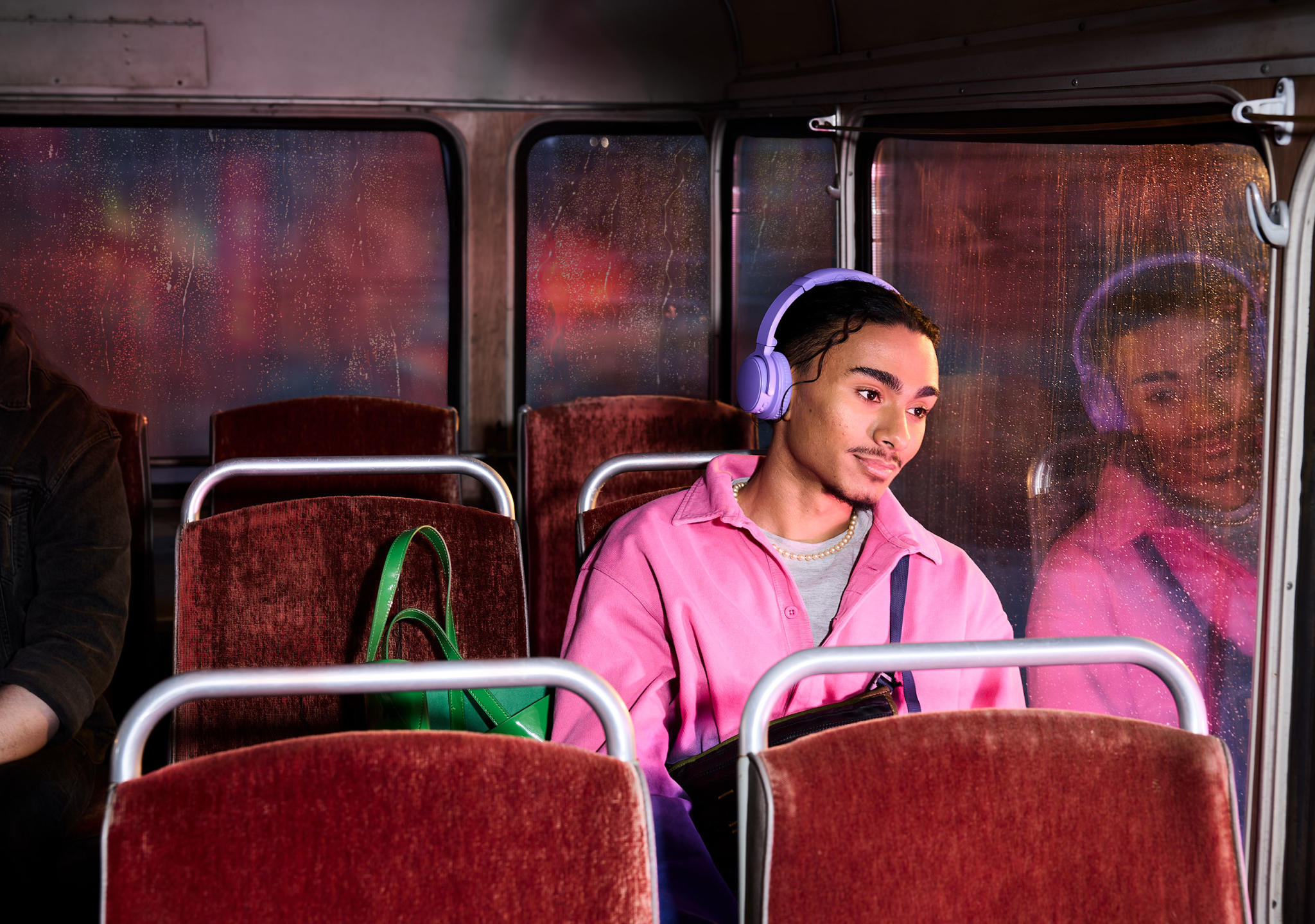 Gutt lytter til lydbøker på bussen og ser ut vinduet.