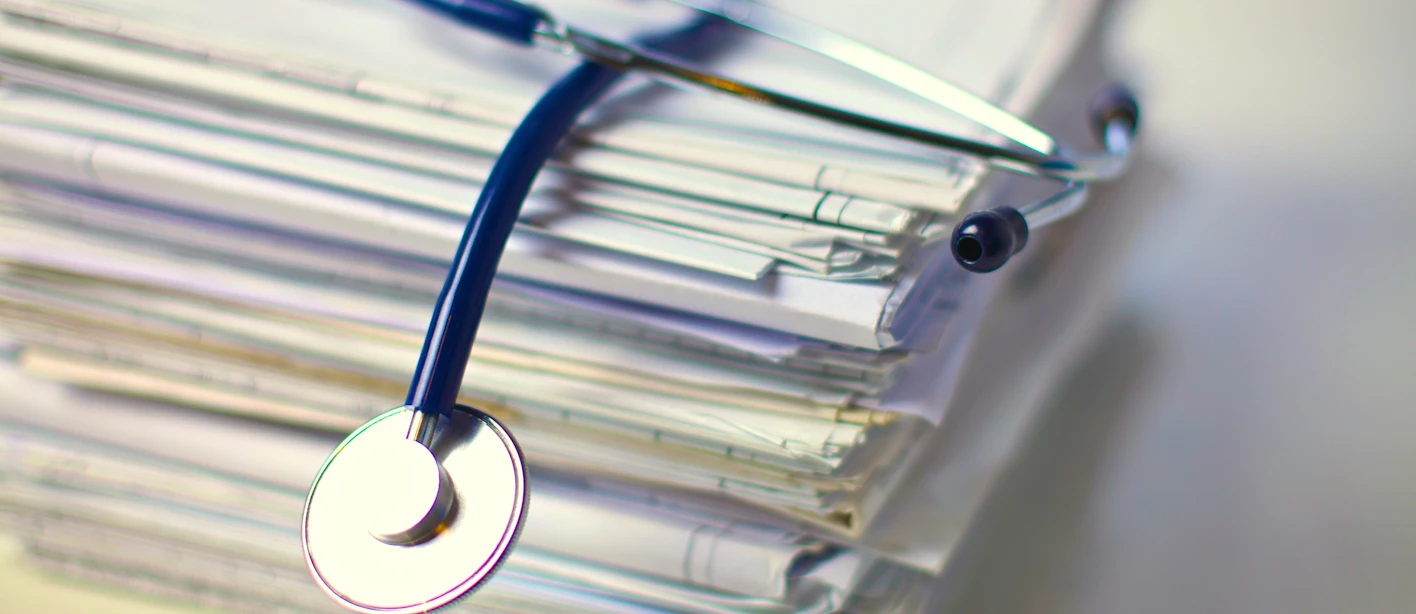 An image of a stethoscope on top of a pile of papers.