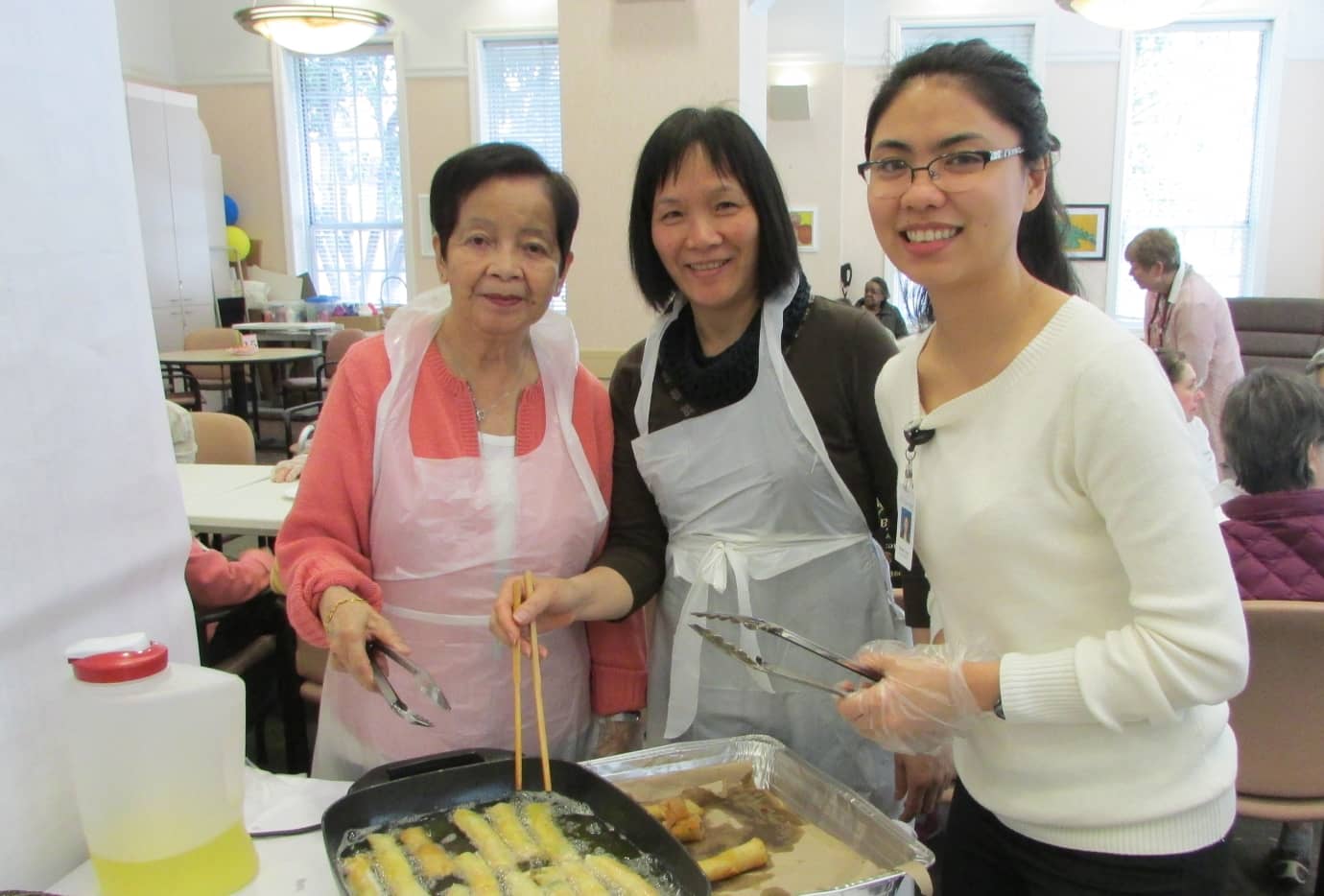 OnLok staff cooking eggrolls for the elderly patients during a saturday service