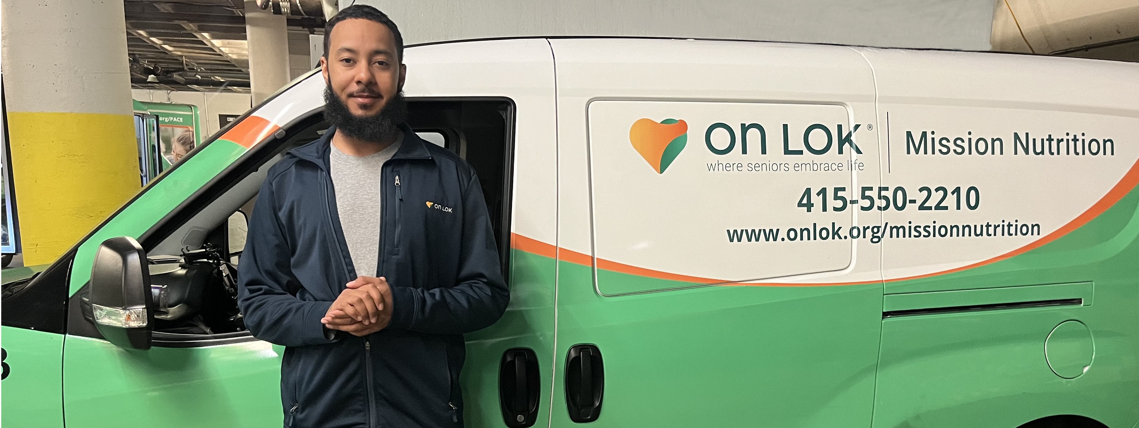 On Lok Medically Tailored Meals program driver standing in front of the MTM program van.