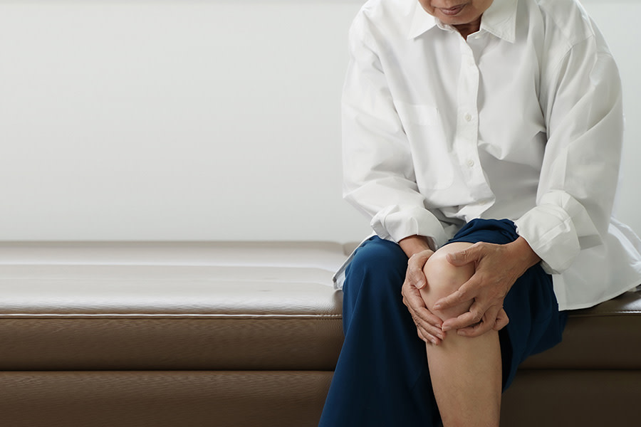 Knieschmerzen: Frau mit starken Knieschmerzen