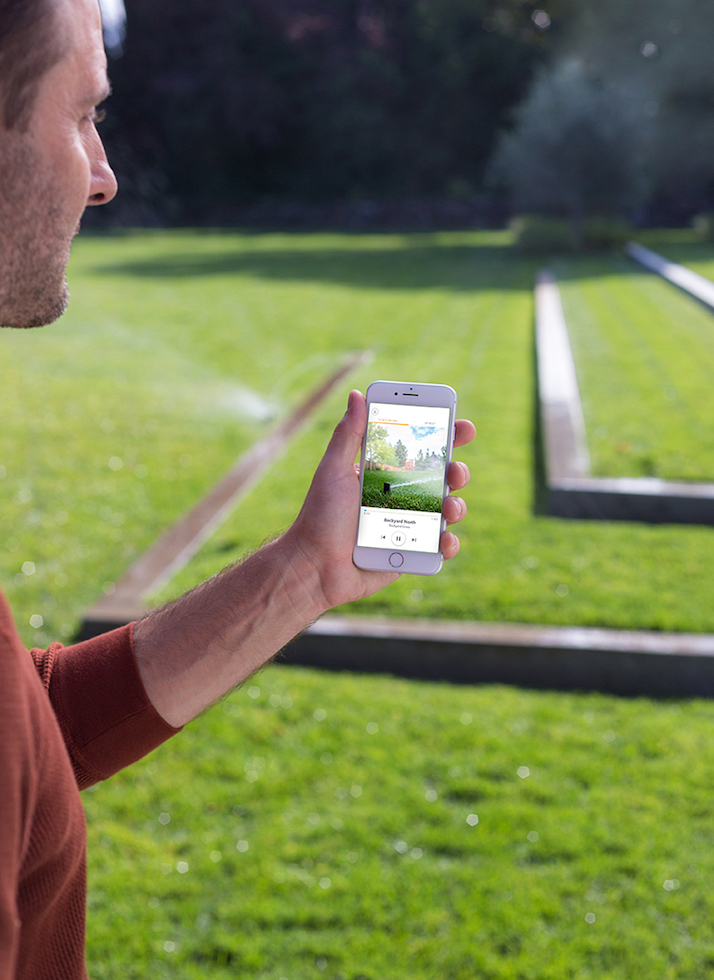 Person using Rachio mobile app in their yard